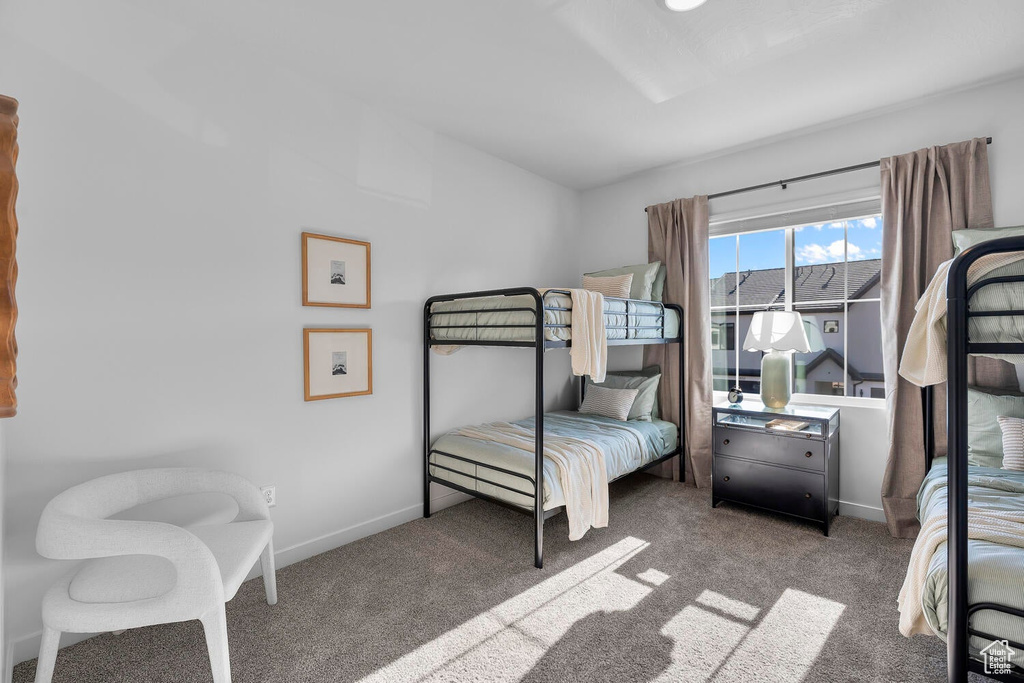 Bedroom featuring carpet and baseboards