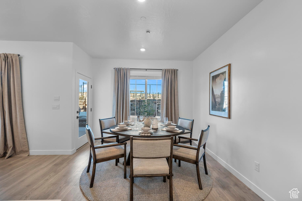 Dining area with baseboards, light wood-type flooring, and recessed lighting