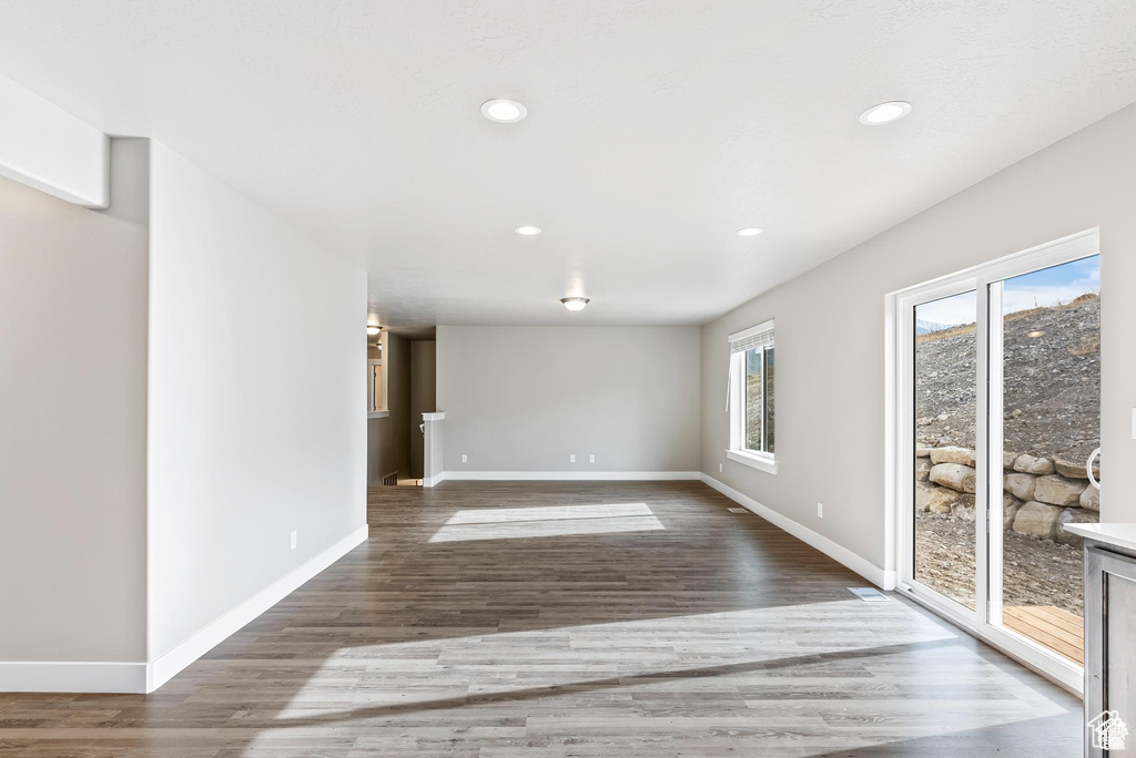 Empty room with baseboards, wood finished floors, and recessed lighting