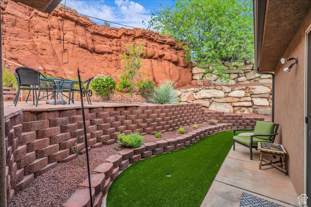 View of yard featuring a patio and an area to practice putting