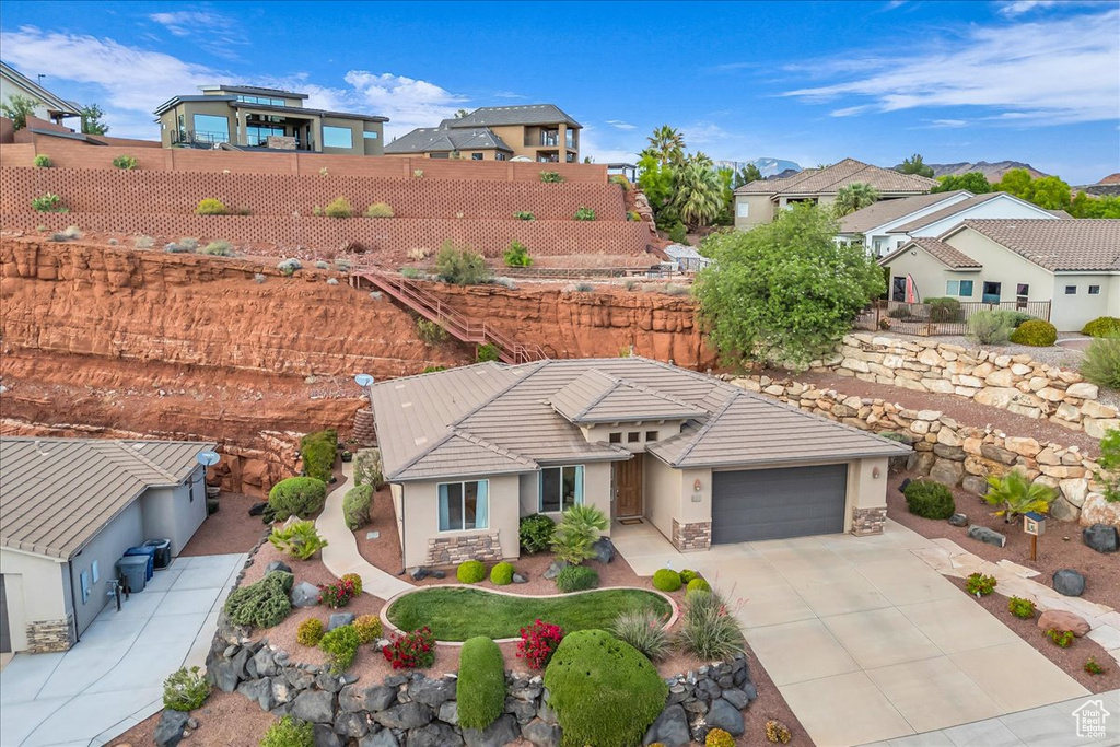 View of front of house featuring stucco siding, fence, concrete driveway, and a residential view