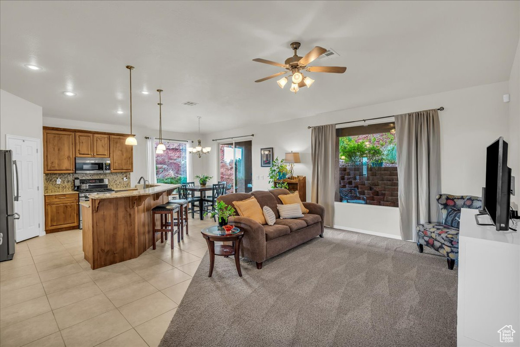 Living area with a ceiling fan, light tile patterned flooring, a chandelier, and recessed lighting