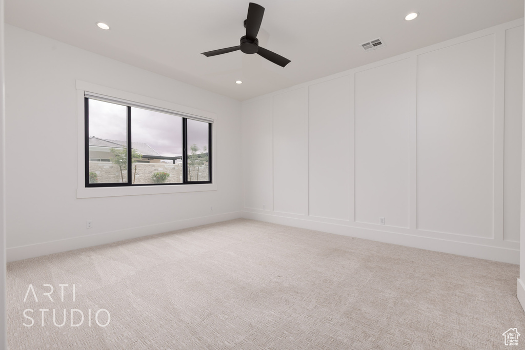 Spare room featuring a decorative wall, light colored carpet, recessed lighting, and ceiling fan