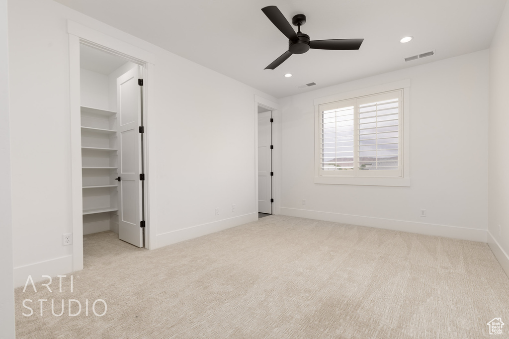 Unfurnished bedroom with carpet, recessed lighting, baseboards, a walk in closet, and a ceiling fan
