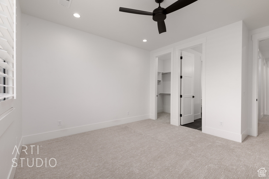 Unfurnished bedroom featuring carpet flooring, a spacious closet, recessed lighting, baseboards, and ceiling fan