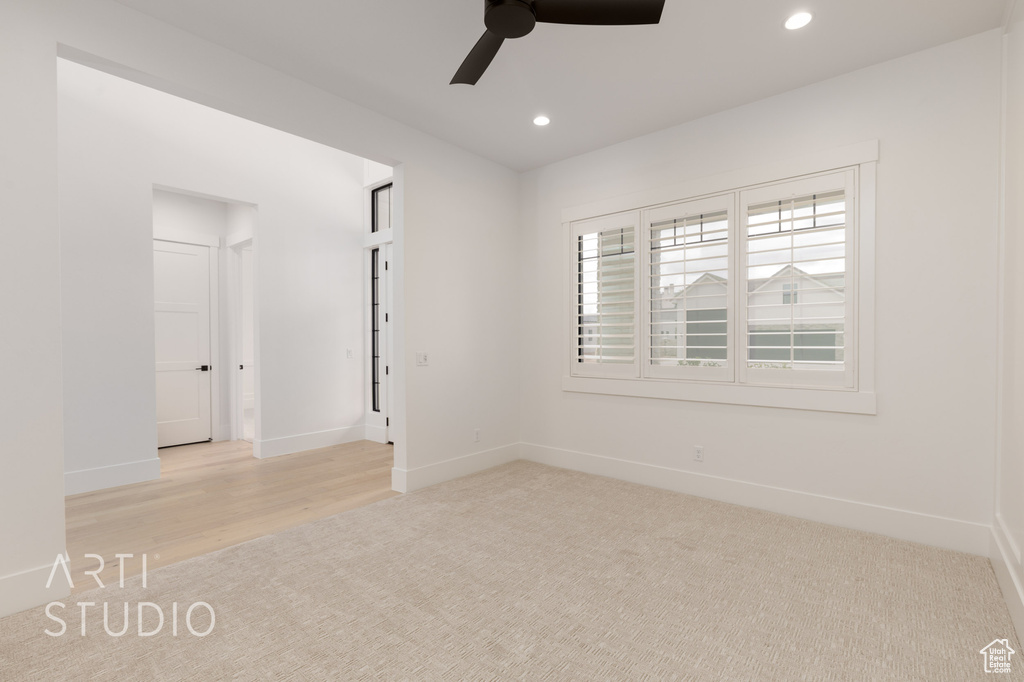 Spare room with ceiling fan, recessed lighting, baseboards, light carpet, and light wood finished floors