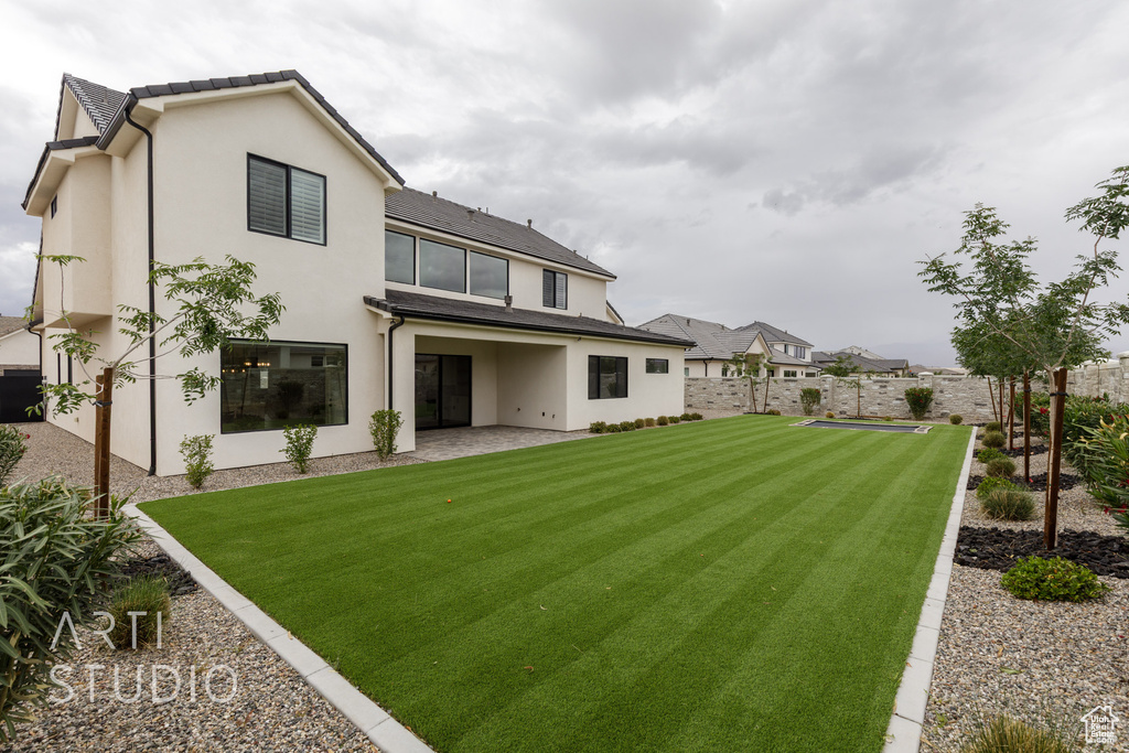 Back of house featuring stucco siding and a patio
