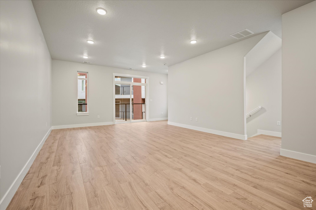 Unfurnished living room featuring light wood-style floors, baseboards, and recessed lighting