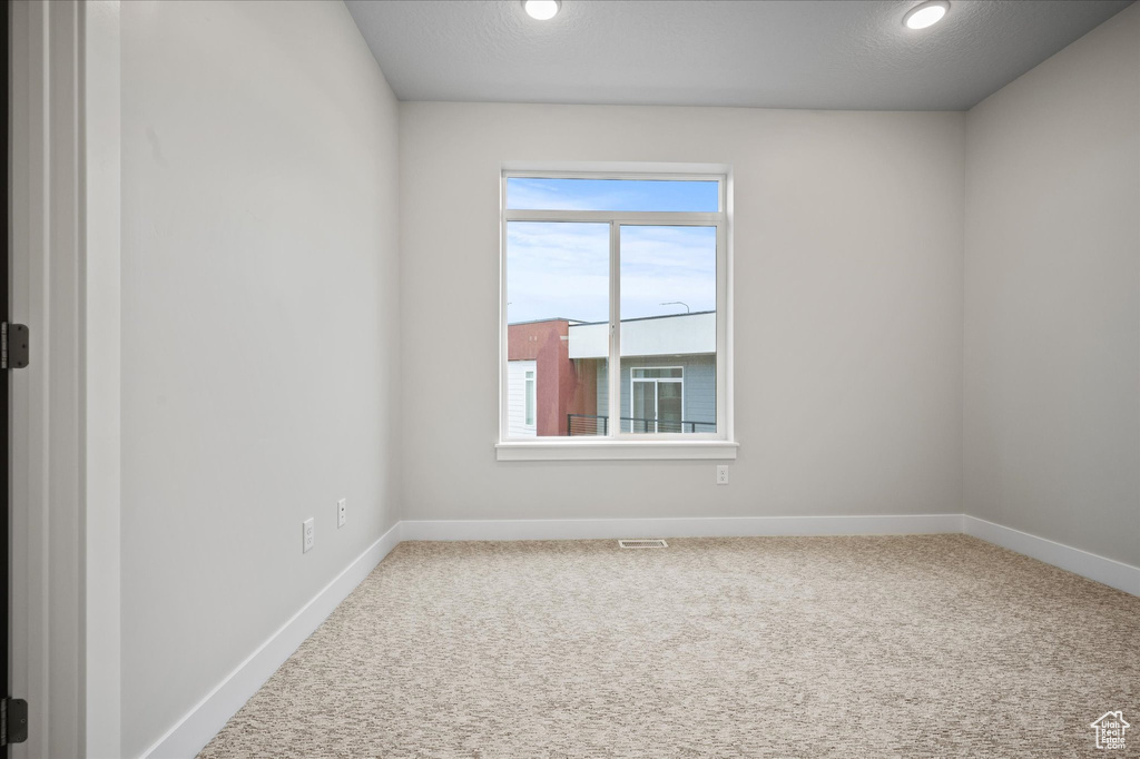 Spare room featuring baseboards, carpet floors, and recessed lighting