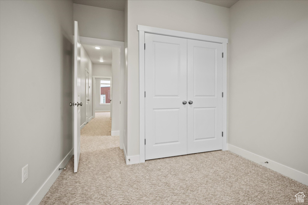 Unfurnished bedroom featuring carpet, baseboards, and a closet