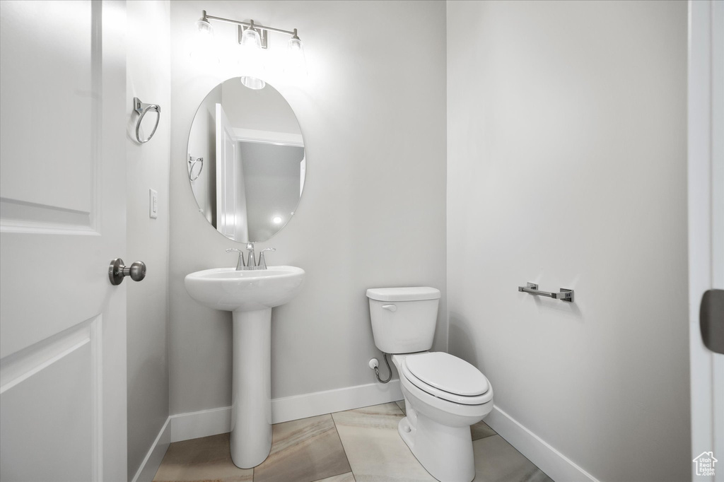 Half bathroom featuring toilet and baseboards