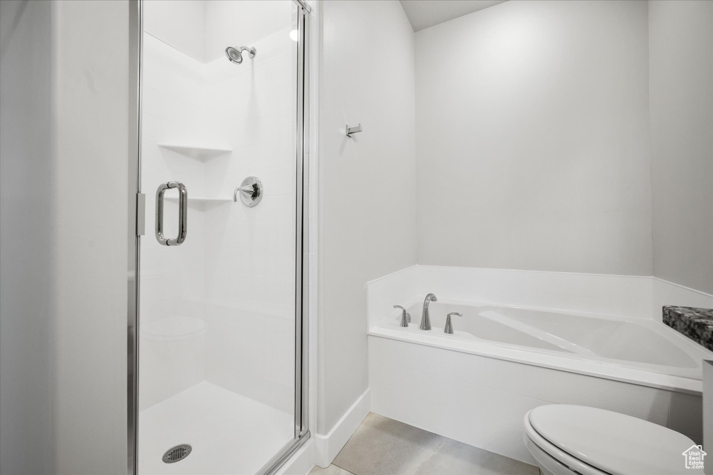 Bathroom with a shower stall, toilet, and a garden tub