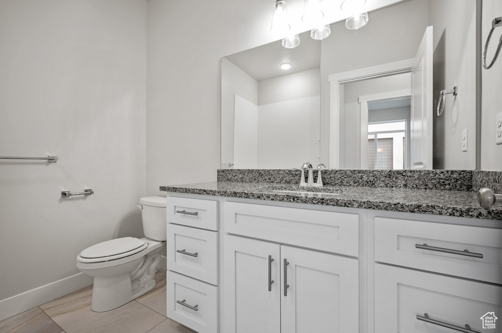 Bathroom featuring toilet, baseboards, and vanity