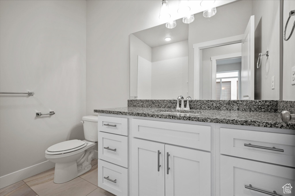 Bathroom featuring toilet, baseboards, and vanity