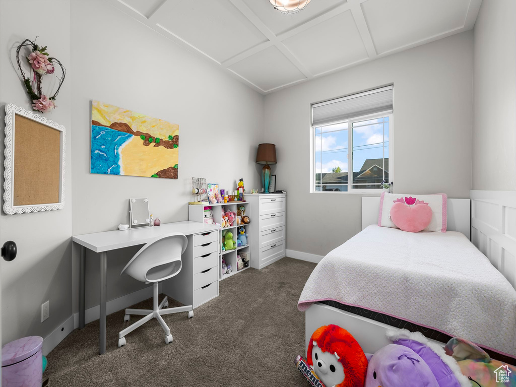 Bedroom with dark colored carpet, coffered ceiling, and baseboards