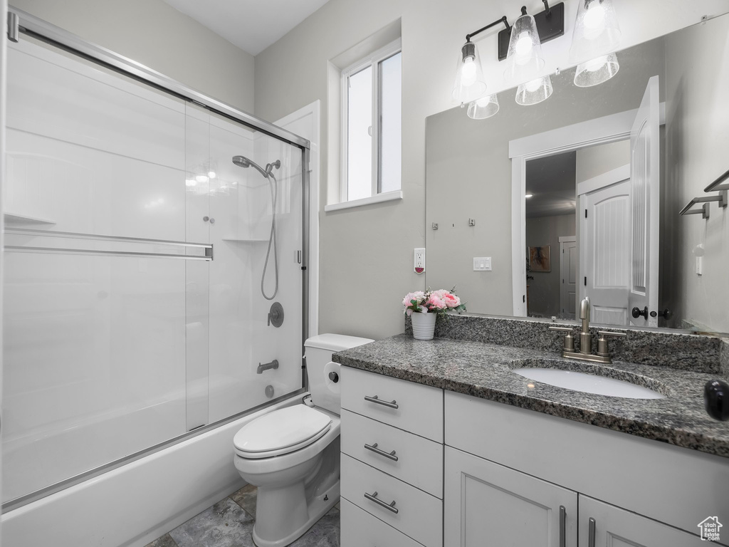 Full bath featuring toilet, vanity, and enclosed tub / shower combo