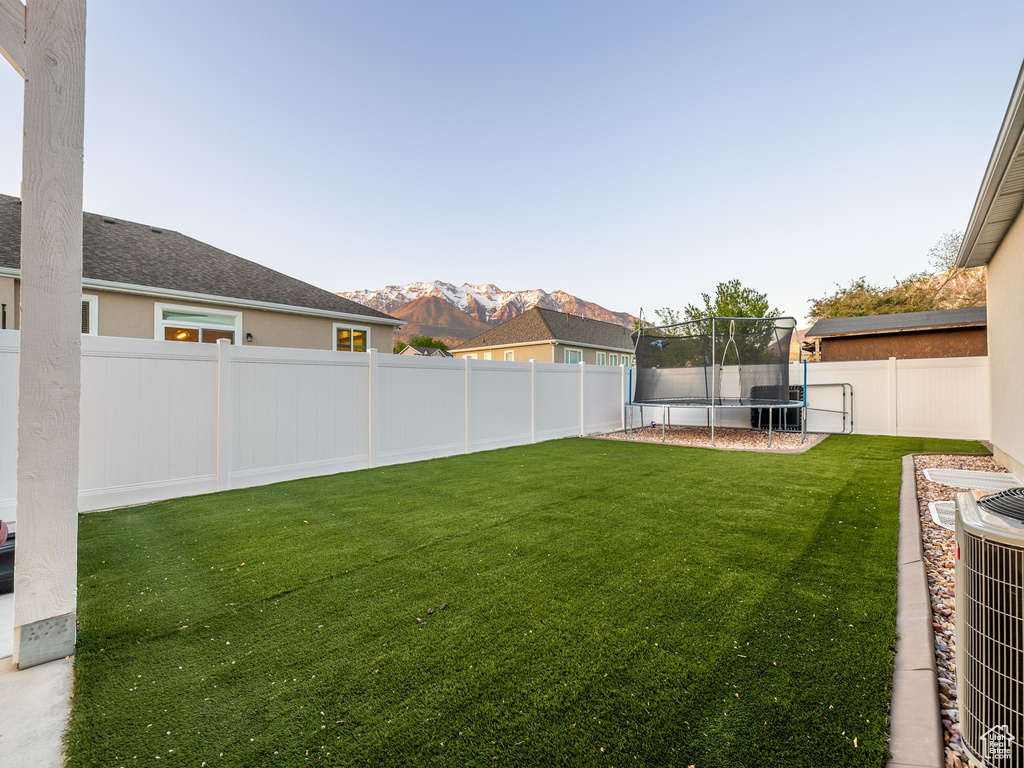 View of yard featuring a trampoline and a mountain view