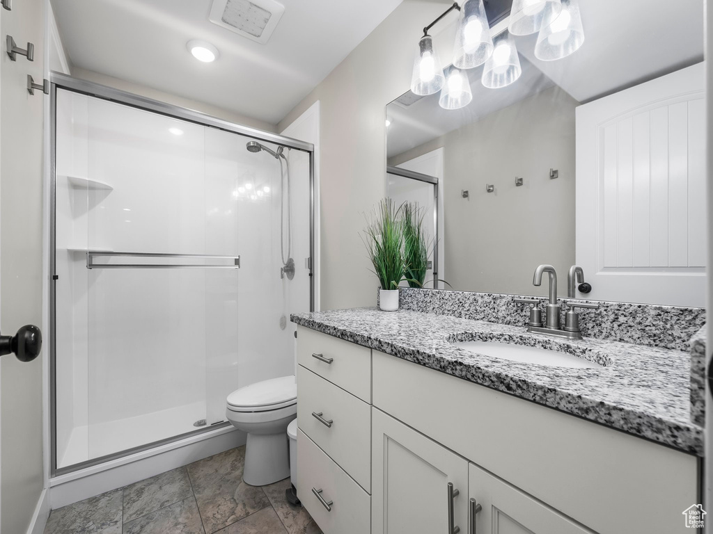 Bathroom with a shower stall, toilet, and vanity