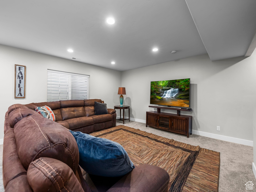 Carpeted living area featuring recessed lighting and baseboards