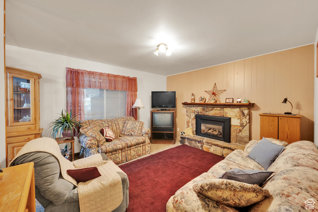 Carpeted living room with a stone fireplace