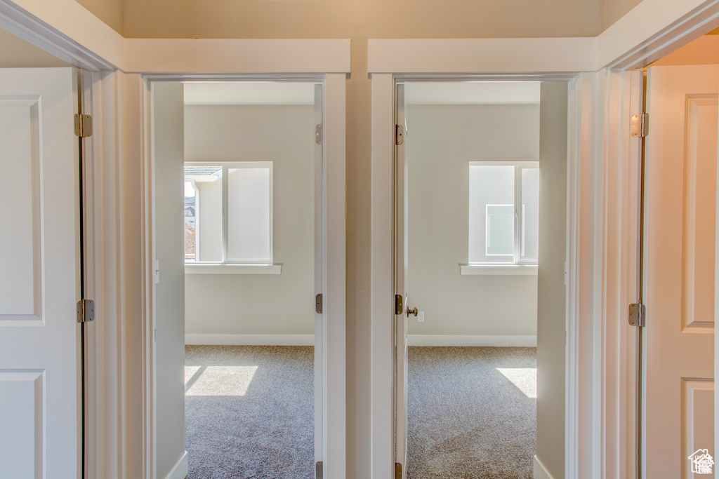 Corridor featuring carpet flooring and baseboards