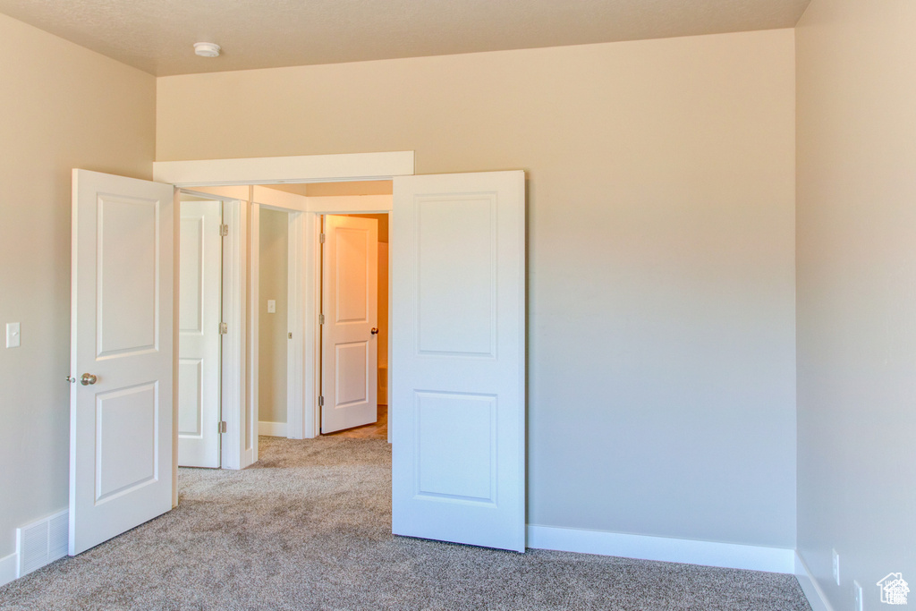 Carpeted spare room with baseboards