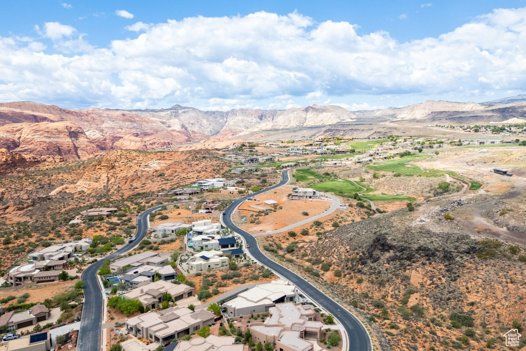 Aerial view of property's location with a mountain backdrop and nearby suburban area