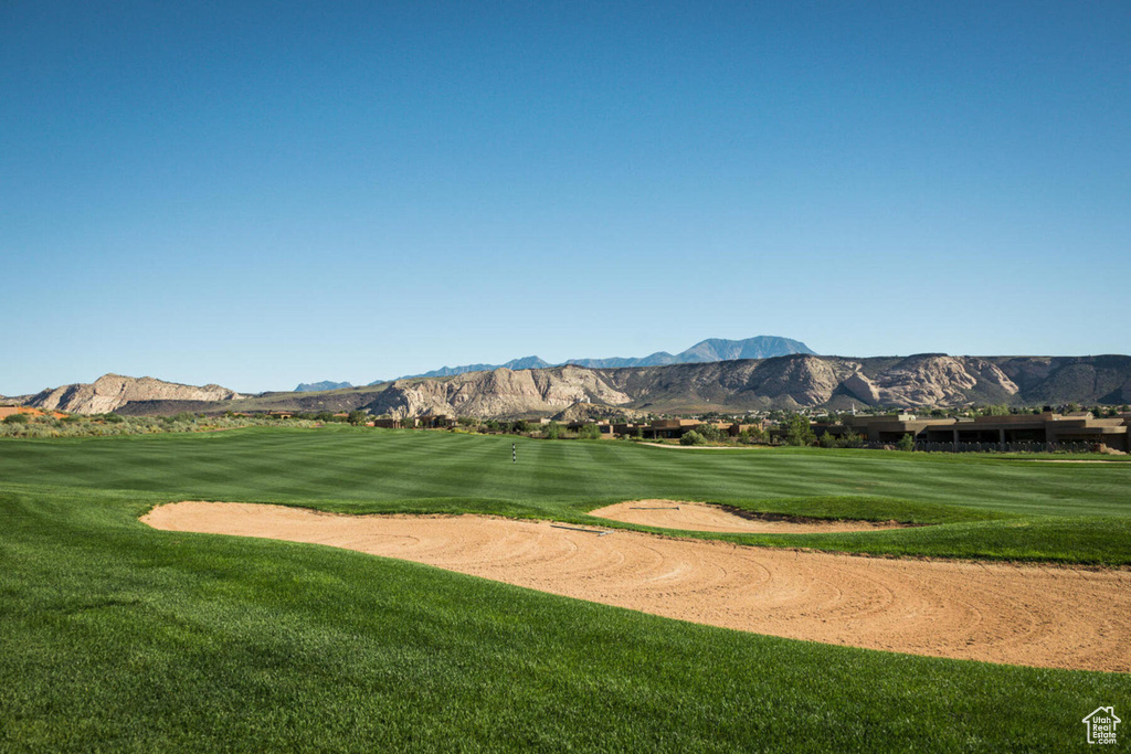 View of home's community featuring golf course view, a mountain view, and a yard