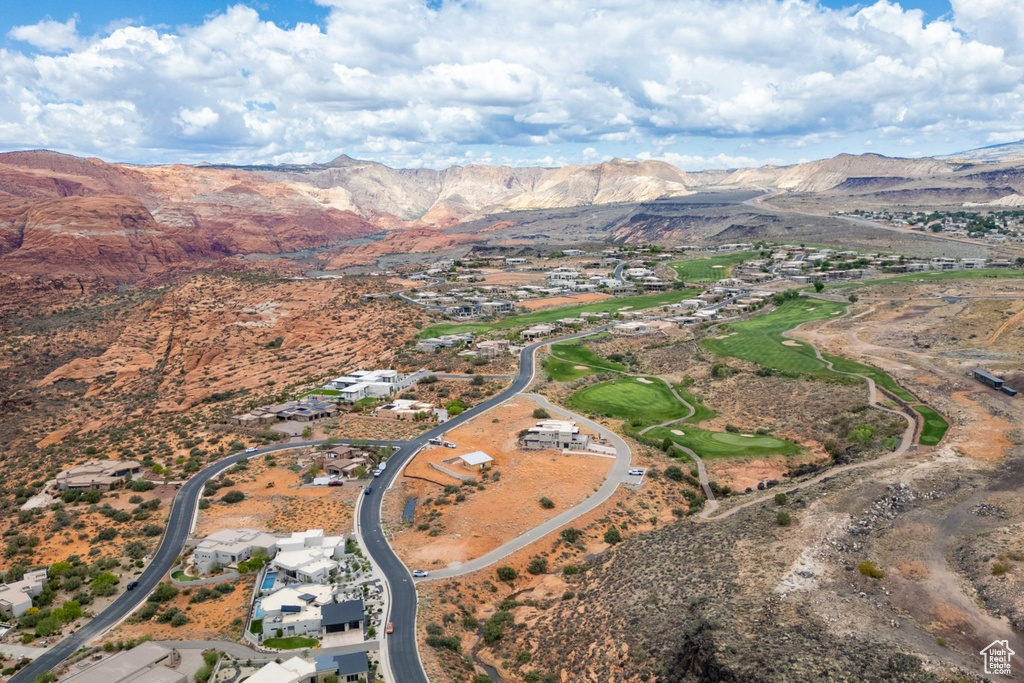 Aerial view of property and surrounding area with a mountain backdrop and nearby suburban area