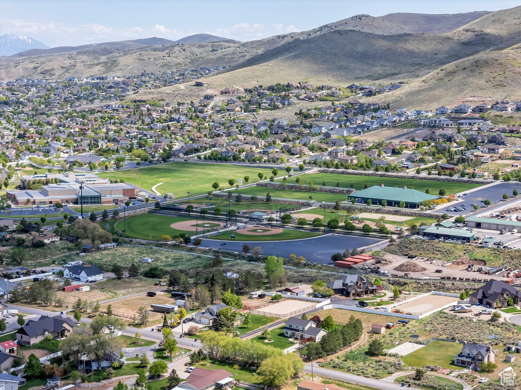 Aerial view of property and surrounding area with a mountain backdrop and nearby suburban area