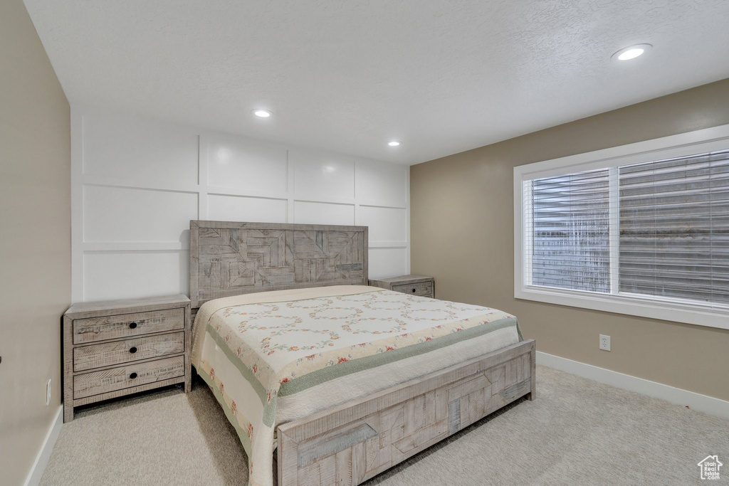 Bedroom with light colored carpet, recessed lighting, and baseboards