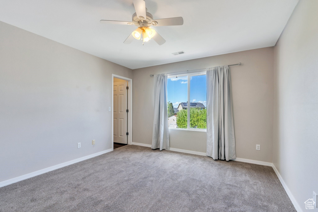 Unfurnished room with ceiling fan, carpet flooring, and baseboards