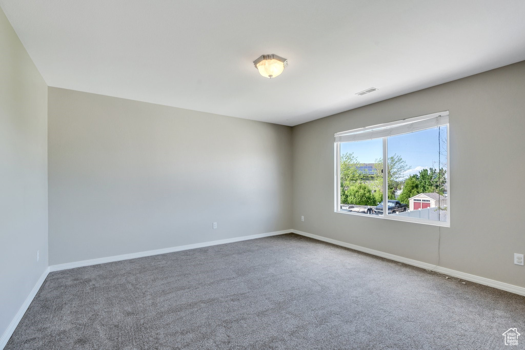 Carpeted empty room with baseboards