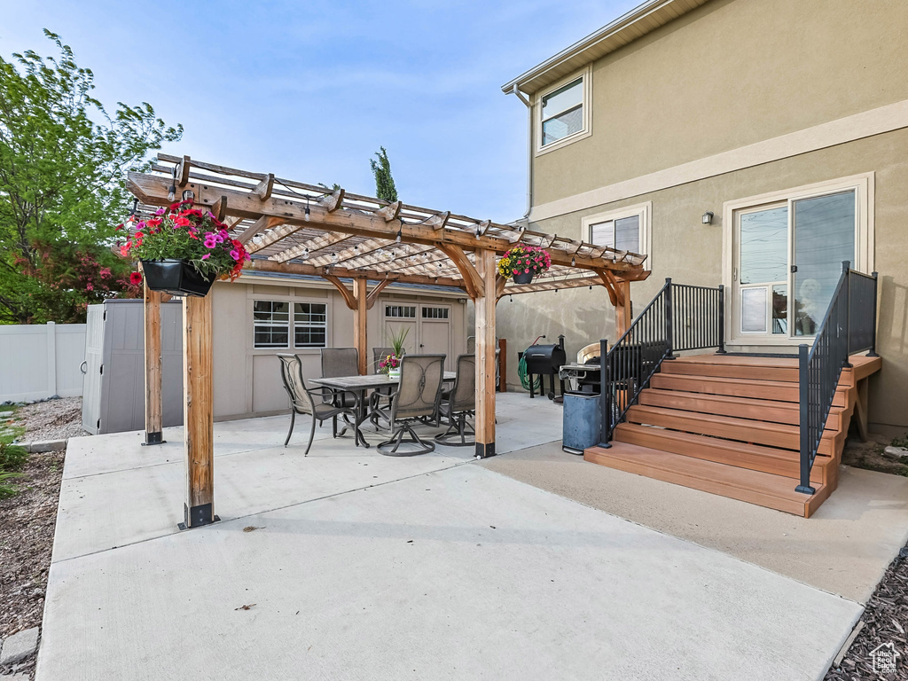 Rear view of house with a fenced backyard, a patio area, stucco siding, and a pergola