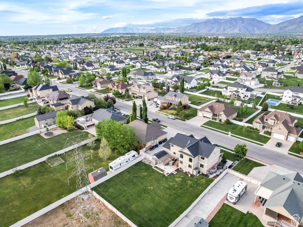 Aerial view of property and surrounding area with mountains and nearby suburban area
