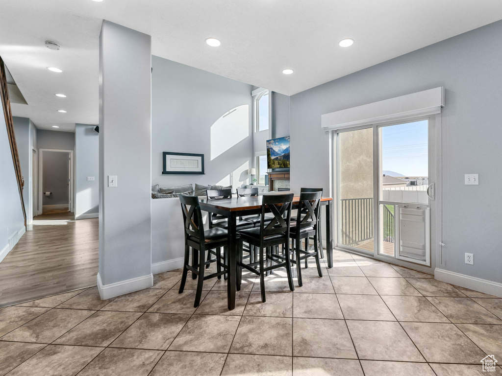 Tiled dining area with baseboards and recessed lighting