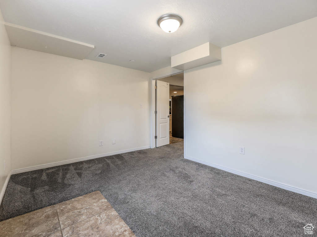 Carpeted spare room featuring baseboards
