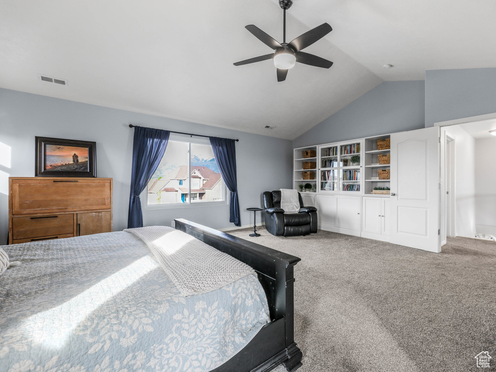 Carpeted bedroom with vaulted ceiling and a ceiling fan