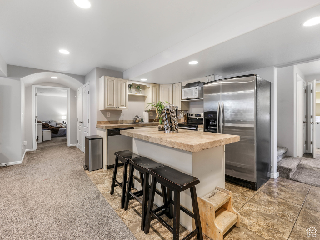 Kitchen featuring appliances with stainless steel finishes, washer / clothes dryer, recessed lighting, a center island, and open shelves