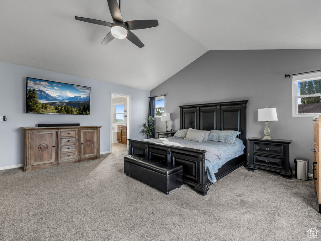 Carpeted bedroom featuring vaulted ceiling, ceiling fan, connected bathroom, and baseboards