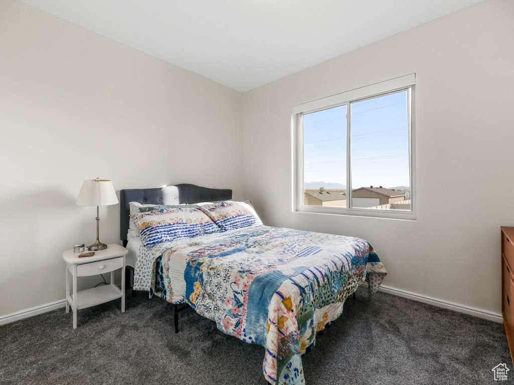 Bedroom featuring carpet and baseboards