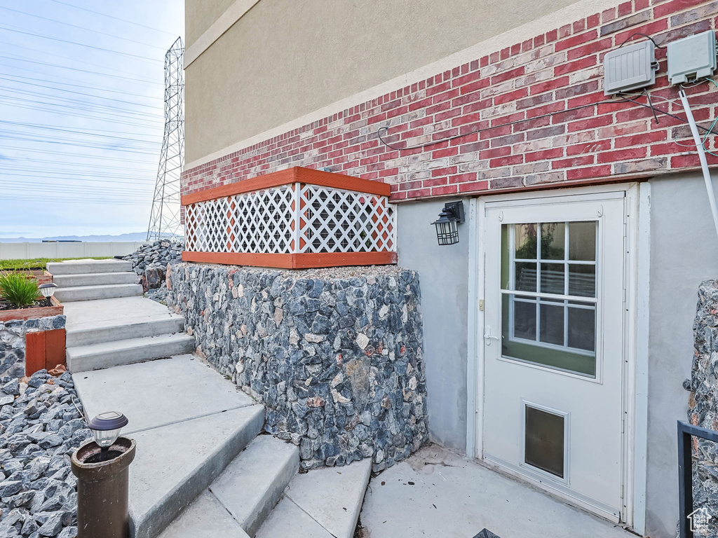 Doorway to property featuring stucco siding