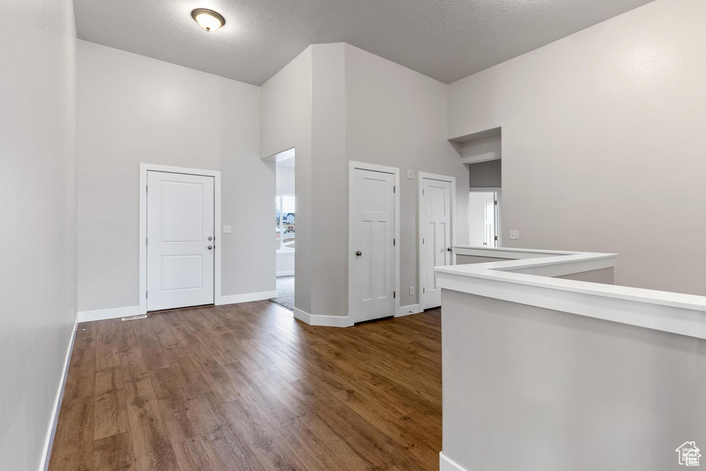 Entryway with a towering ceiling, wood finished floors, and baseboards