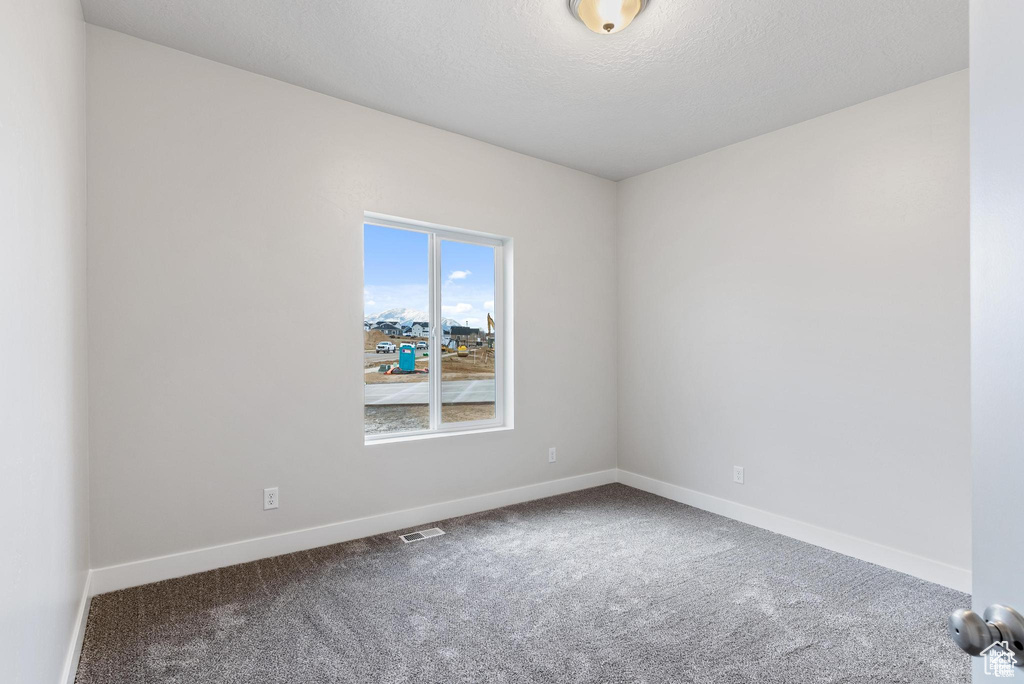 Spare room with carpet and baseboards