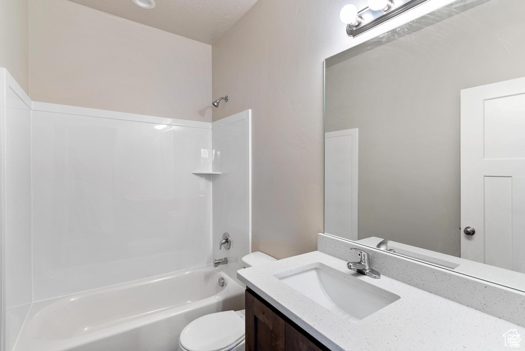 Bathroom featuring shower / washtub combination, toilet, and vanity