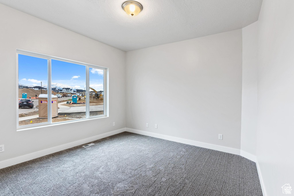 Spare room featuring carpet floors and baseboards