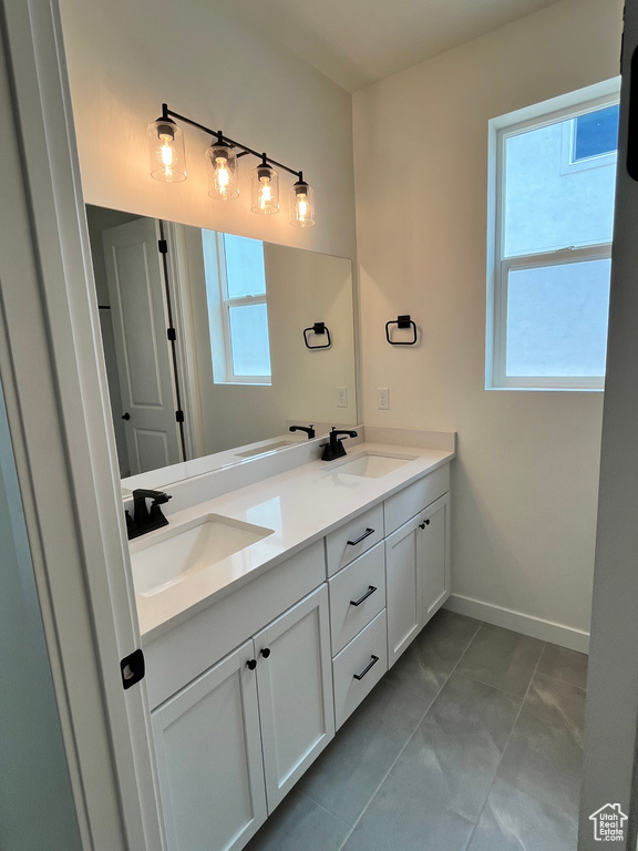 Full bath featuring double vanity and baseboards