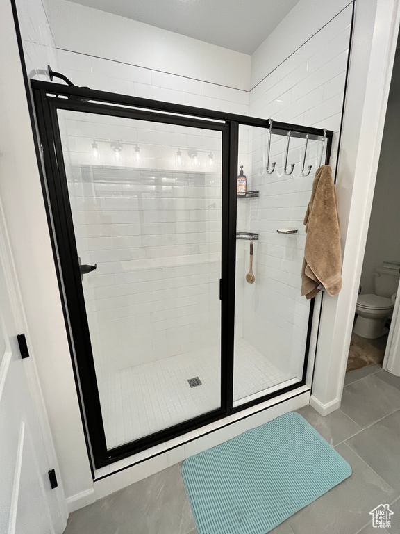 Full bathroom featuring a stall shower and toilet