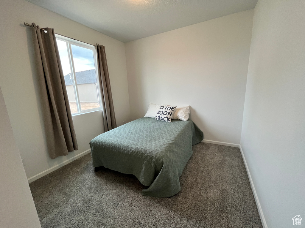 Bedroom featuring baseboards and carpet