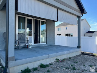 Back of house with fence, a deck, and stucco siding